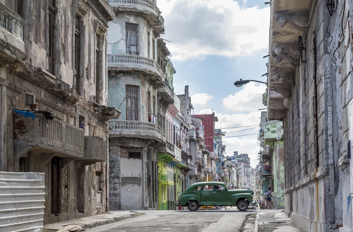 A vintage American car driving down a street in Centro Habana, Havana, Cuba