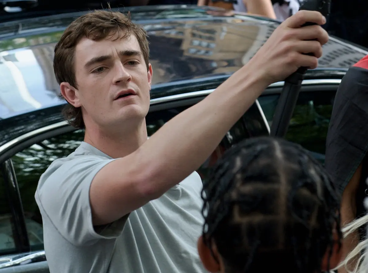 Nick Shirley filming with a phone on a gimbal on a Manhattan street in 2025